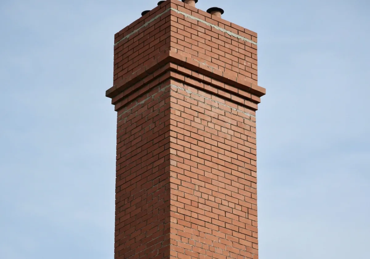 After — chimney repair: Spalled brick and failing mortar rebuilt into a sound, weather-tight stack.